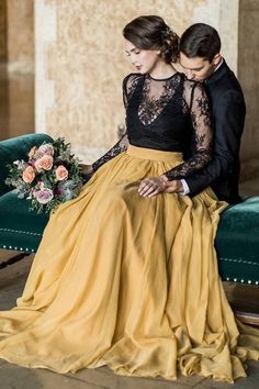 a man and woman in formal wear sitting on a couch