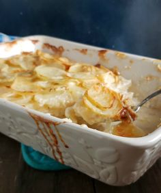 a casserole dish with potatoes and gravy on the side, ready to be eaten