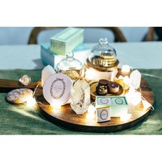 an assortment of pastries are displayed on a wooden platter with lights around them