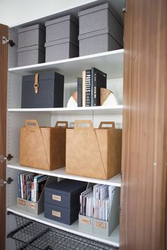 the shelves have bins, boxes and file folders on them in order to keep things organized