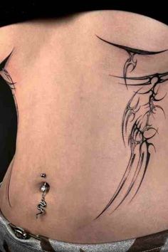 a woman's back with a tattoo design on her lower body and the bottom part of her stomach