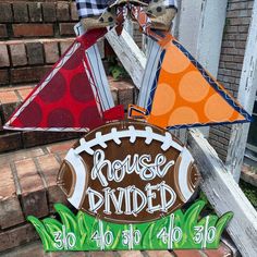 a sign that says house divided and a football on it with a kite hanging from the top