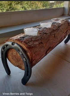 a bench made out of a log with tea cups on it sitting in front of a window