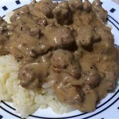 a white plate topped with rice and meat covered in gravy