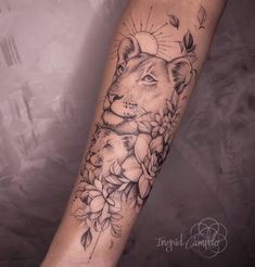 a woman's arm with a lion and flowers tattoo on it