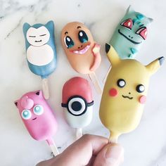 a hand is holding several pokemon lollipops