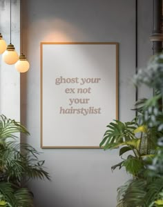 a white poster hanging on the wall next to some potted plants and two lamps