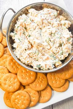 a platter filled with crackers and a bowl of chicken salad on the side