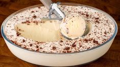 an ice cream dessert in a glass bowl with a scoop full of ice cream and chocolate chips