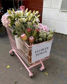 a pink shopping cart filled with lots of flowers