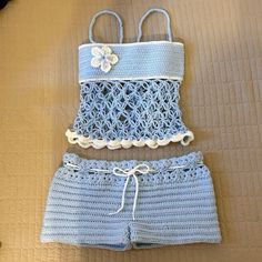 a crocheted swimsuit and shorts are laying on a bed