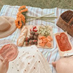 a picnic blanket with food and drinks on it