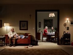 an older man and woman sitting on a couch in a living room next to each other