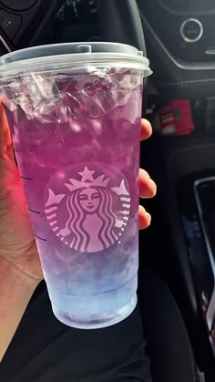 a person holding up a pink drink in their hand