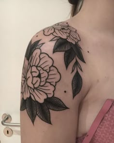 a woman's shoulder with black and white flowers on it