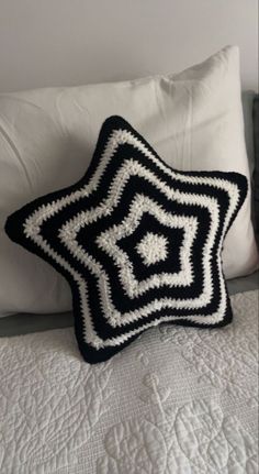 a black and white crocheted star pillow on a bed