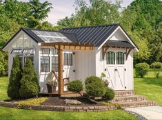 a small white shed with a black roof