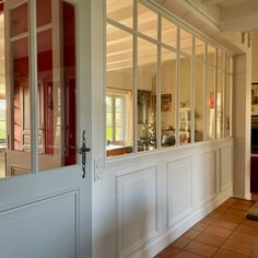 an open door leading to a kitchen and dining room with tile flooring in front of it