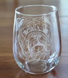 a glass with a dog's face drawn on it sitting on a wooden table