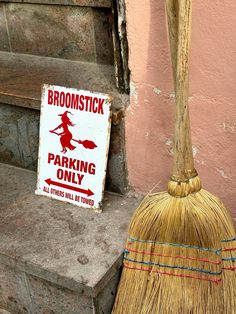 broom sitting on the steps next to a parking only sign