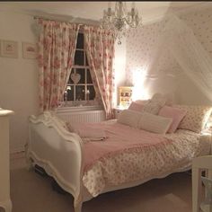 a bed room with a neatly made bed and a chandelier