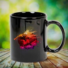 a black coffee mug sitting on top of a wooden table