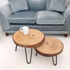 two wooden tables sitting on top of each other in front of a blue couch and chair