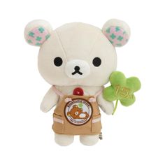 a white teddy bear holding a clover in it's hand