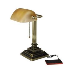 a lamp with a phone plugged into it on a white background and an electronic device next to it