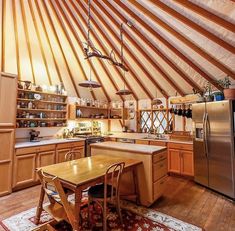 the inside of a yurt with wooden floors and walls, including a dining table