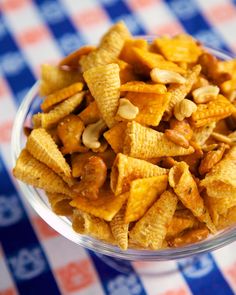 a bowl filled with cheetos sitting on top of a checkered table cloth