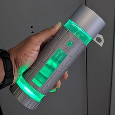 a hand is holding an electronic device with green lights