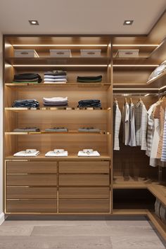 a walk - in closet with wooden shelves and drawers