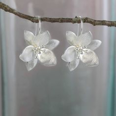 These flower earrings are just that right balance between literal and abstract. A gentle satin finish gives them added shimmer and they balance perfectly on the long ear wire hook.  Size: 25 X 30 mm (drop)  All of my jewellery comes wrapped in tissue paper and packed in a pretty gift Silver Flower Earrings For Spring Gift, Elegant Sterling Silver Flower Earrings For Spring, Spring Silver Flower Shaped Earrings, Spring Silver Flower Earrings, Spring Silver Flower-shaped Earrings, Silver Petal Flower Earrings For Gift, Silver Flower Earrings For Spring, Silver Flower Shaped Earrings For Spring, Handmade Flower-shaped Silver Jewelry