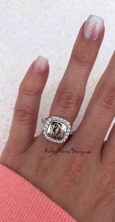 a woman's hand with a pink manicured nails and a ring on it