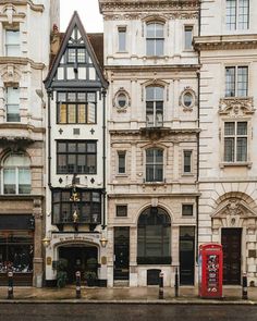 a row of buildings on the corner of a city street with people walking by them