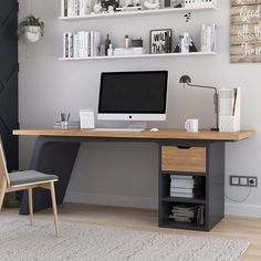 a desk with a computer on top of it in front of a bookshelf