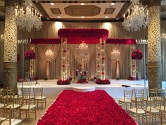 a wedding setup with red flowers and chandeliers