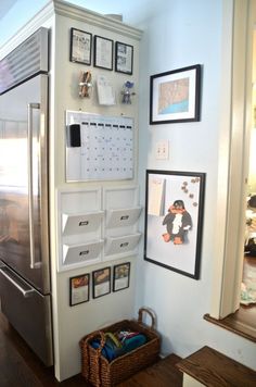 a white refrigerator freezer sitting inside of a kitchen next to pictures on the wall