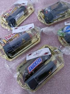 six toy cars in plastic cases on a pink cloth covered table with gold rimmed trays