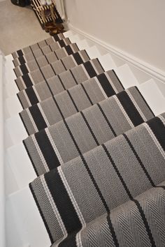 the stairs are lined with black and white carpet