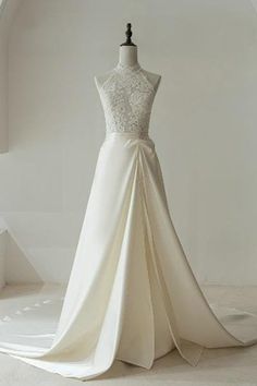 a white wedding dress on display in a room