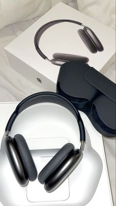 two black headphones sitting on top of a box next to a pair of glasses