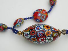 a multicolored beaded necklace on a white surface