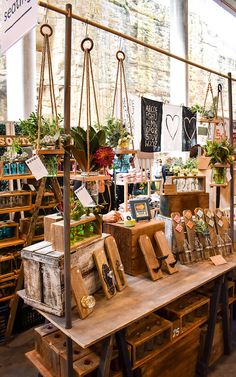 a wooden table topped with lots of boxes filled with plants