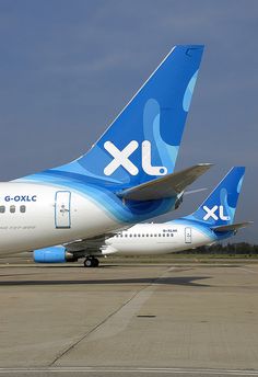 two blue and white airplanes are parked on the tarmac