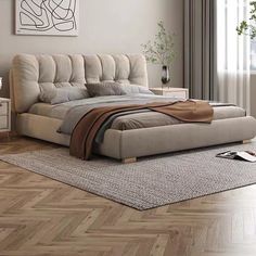 a bed sitting on top of a wooden floor next to a window