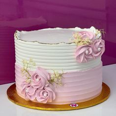 a white and pink cake with flowers on it