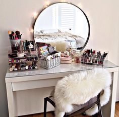 a vanity with a mirror, stool and various makeup products