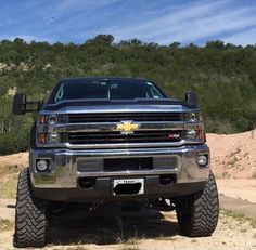 a silver truck parked on top of a dirt road